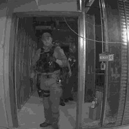 Ajax photo verification: a person in a tactical vest in an interior doorway at night