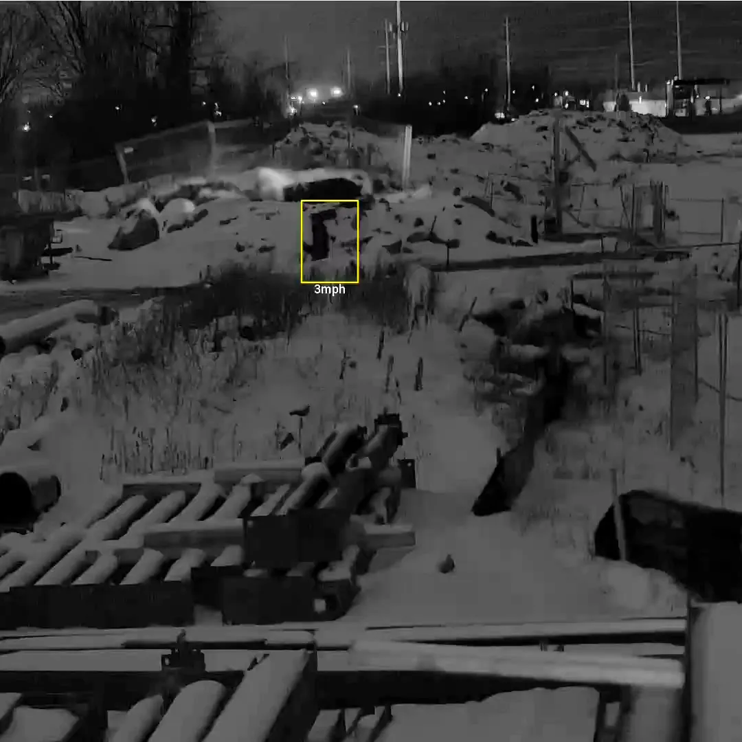 Night camera frame with an analytics box drawn around a person inside the fence line