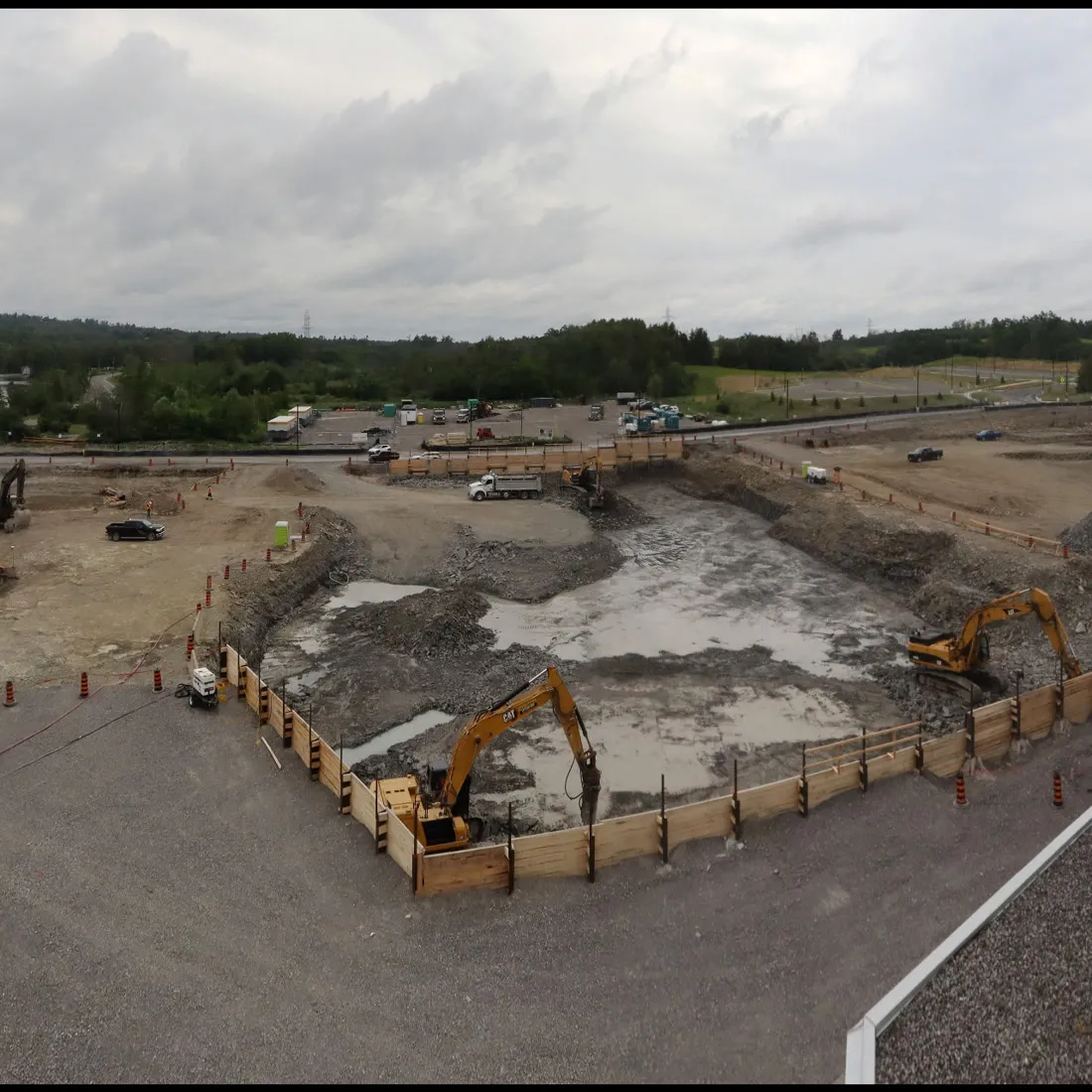 Shored excavation with excavators working across a cleared site