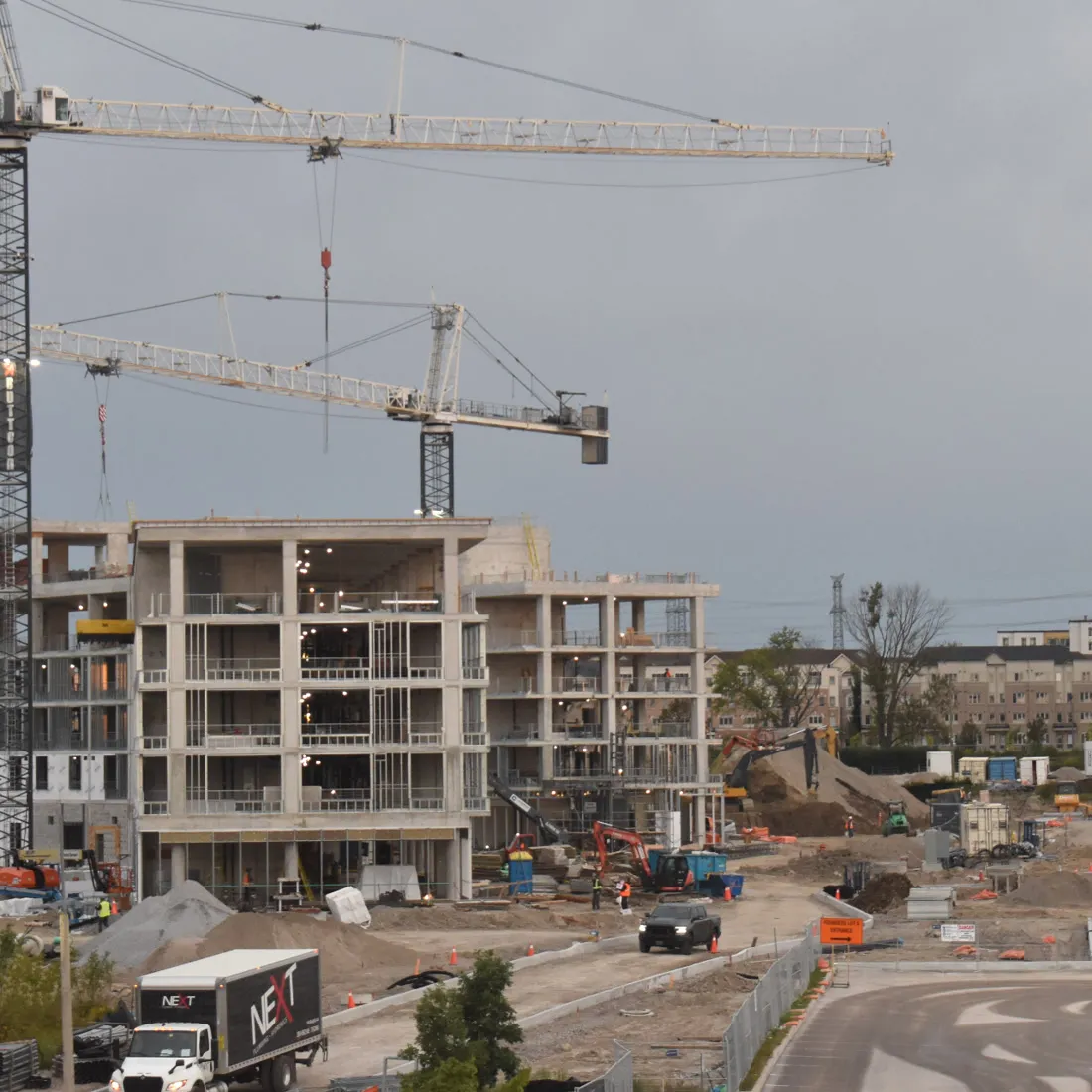 Concrete frame rising under tower cranes on a multi-block site